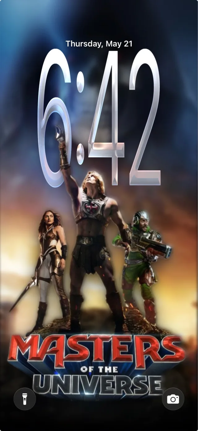 Depthlock lock-screen preview: He-Man's raised arm passes in front of the clock numerals, demonstrating the iOS depth effect